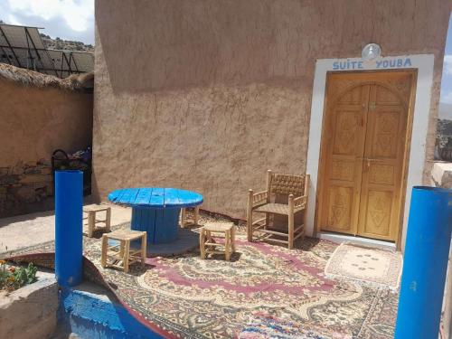 a table and chairs in front of a building with a door at Chez Youba in Rbat