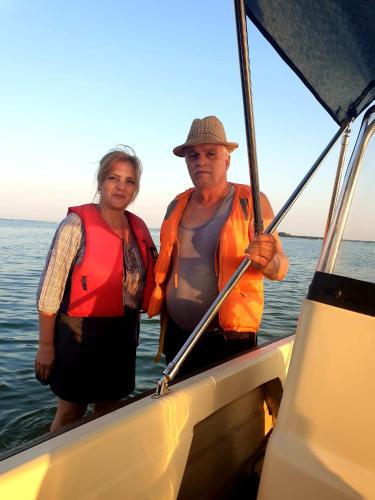 a man and woman standing on a boat in the water at Casa orizont in Sulina