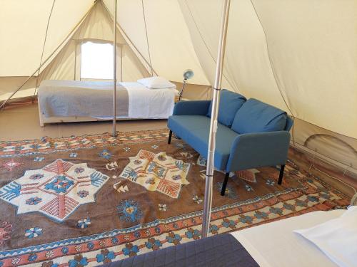 Una habitación con una cama y una silla en una tienda de campaña en COMPORTA SIDE - Tents, en Setúbal