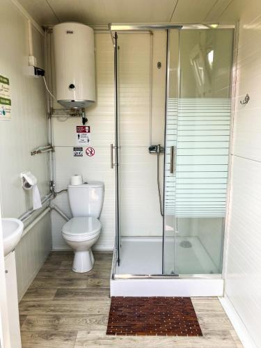 a bathroom with a shower and a toilet at Mazury Glamping Kruklanki Polana Życzeń in Kruklanki