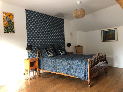 1 dormitorio con 1 cama con edredón azul y blanco en Maison-Gite Chez Roland, en Distré