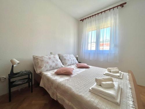 a bedroom with a bed with towels on it at Apartment Troisa in Kaštela