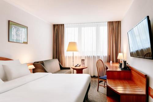 a hotel room with a bed and a desk at Hotel Mercure Toruń Centrum in Toruń