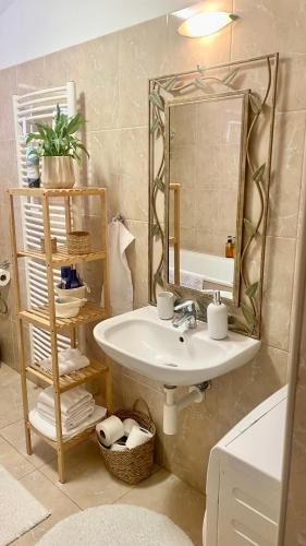 a bathroom with a sink and a mirror at Sunny Attic Apartment in Zvolen