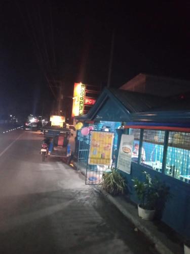a building on the side of a street at night at Bossing Inasal in Tubigon