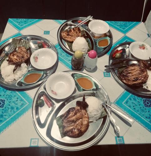 a table with several plates of food on it at Bossing Inasal in Tubigon