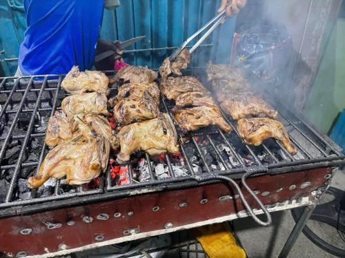a bunch of chickens cooking on a grill at Bossing Inasal in Tubigon