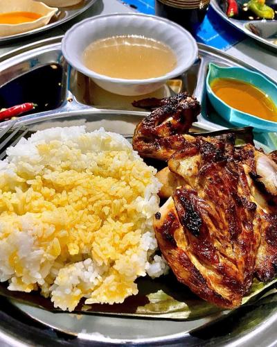 un piatto di alimenti a base di riso, pollo e altri alimenti di Bossing Inasal a Tubigon
