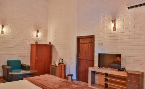 a hotel room with a bed and a tv and a room at Tepraas Sigiriya in Sigiriya