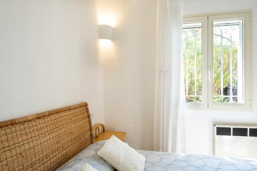 a bedroom with a bed and a window at Villa Baja Sardinia con piscina e vista in Baja Sardinia
