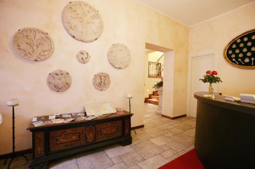 ベルガモにあるラ ヴァレッタ ルレのテーブルと皿が壁に掛けられた部屋