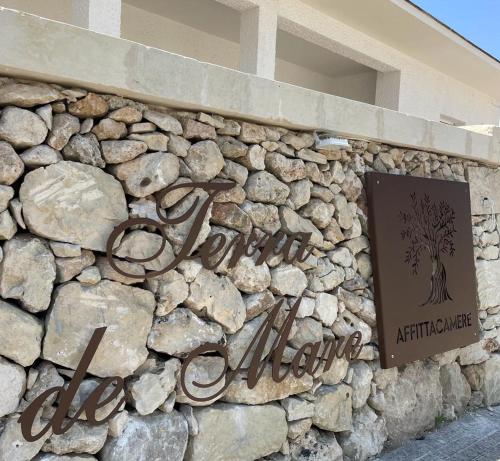 a stone wall with a sign on a building at Terra De Mare in Palmariggi