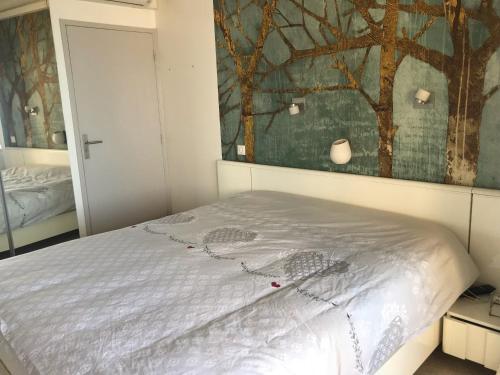 une chambre avec un lit avec un tableau sur le mur dans l'établissement Le Rocher Des Sanguinaires, à Ajaccio