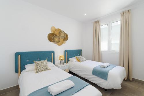 Ereza Villas Salitre في بويرتو كاليرو: سريرين في غرفة ذات لون أبيض وأزرق