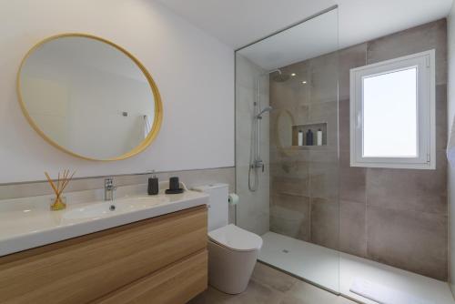 ein Badezimmer mit einem Waschbecken, einem WC und einem Spiegel in der Unterkunft Ereza Villas Salitre in Puerto Calero