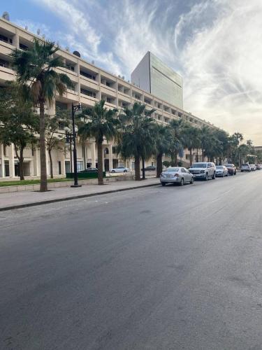 una calle con coches estacionados frente a un edificio en Al Khozama Executive Apartments, en Riad