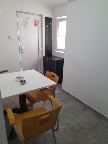 a table and chairs in an office with a white table at LIBERO APARTMANI in Surčin
