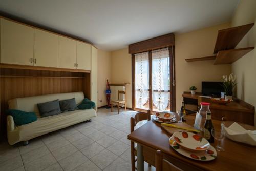 a kitchen and living room with a couch and a table at La Tana al sole in Brescia