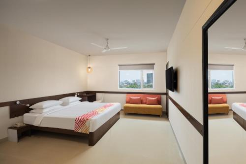 a bedroom with a bed and a couch and a tv at Ginger Mumbai Andheri (MIDC) in Mumbai