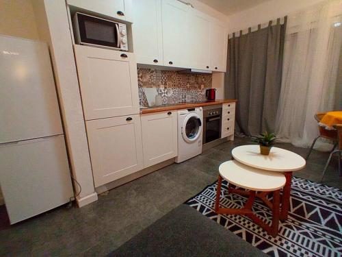 eine kleine Küche mit Waschmaschine und Trockner in der Unterkunft Sesimbra Charming Pool Duplex BBK & Garden in Sesimbra
