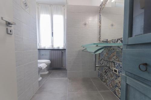 a bathroom with a sink and a toilet and a window at The Breeze Way in Piombino