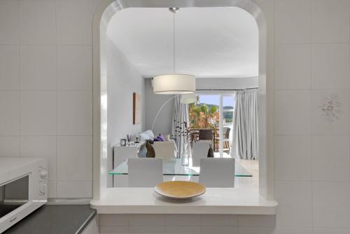 una cocina con una barra con un plato. en Apartamento en complejo con piscina, pádel y restaurante con vistas al golf en Mijas - Matchroom 83, en Fuengirola