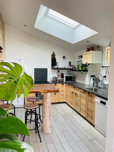 une cuisine avec des armoires en bois et une table en bois dans l'établissement la P’tite Grange, à La Cotinière