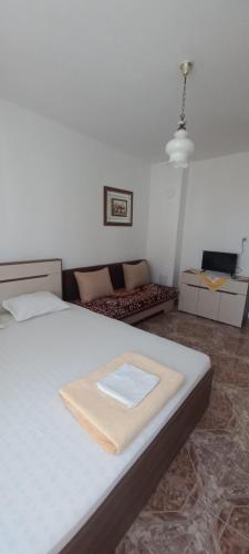 a bedroom with a white bed and a couch at Casa Branca in Sozopol
