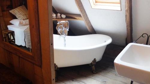 uma banheira na casa de banho com um lavatório em De Schaapskooi em Hezingen