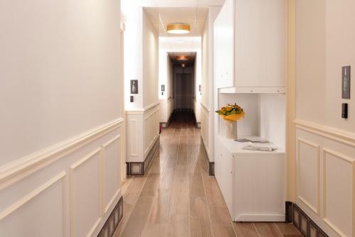 korytarz z białymi ścianami i drewnianą podłogą oraz korytarz z: w obiekcie Gli Appartamentini del Bistrot dei Vinai w mieście Cuneo
