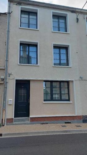 a building with a black door and several windows at Mister Hinster - studio tout confort centre ville Nogent-le-Rotrou - 1e étage in Nogent-le-Rotrou