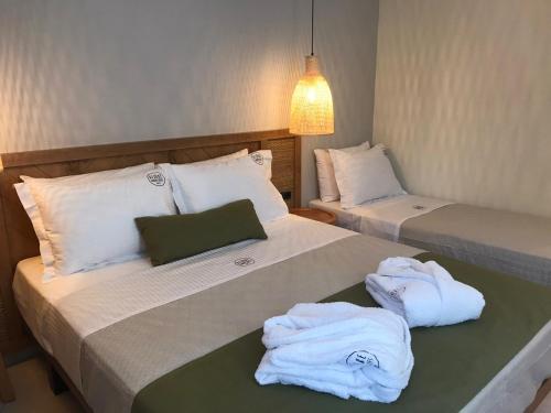 twee bedden in een kamer met handdoeken erop bij Azzure Luxury Suites in Potos