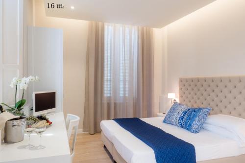 a bedroom with a bed and a desk with a television at Hotel Europa in Lido di Camaiore