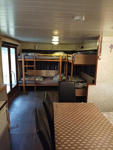 a room with a table and chairs and bunk beds at Mobilheim in Mohelno