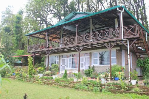 a house with a balcony on top of it at Forest Side Farm - Homestay at Kotabagh Near Nainital and Jim Corbett in Kota Bāgh