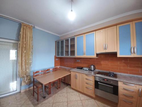a kitchen with wooden cabinets and a wooden table with a tableablish at Arjana & Nelaj Apartments in Ksamil