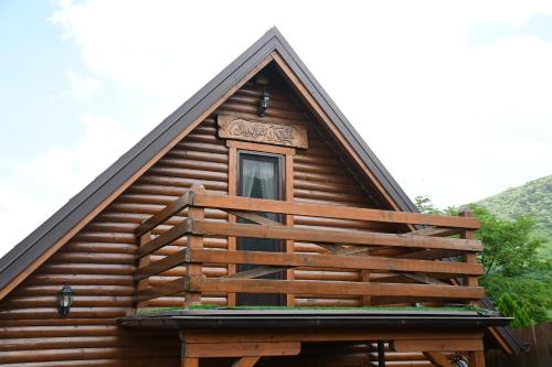 a log cabin with a porch and a window at Milošev Konak in Malo Središte