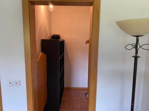 a hallway with a black refrigerator and a lamp at GENSLEITEN in Reut