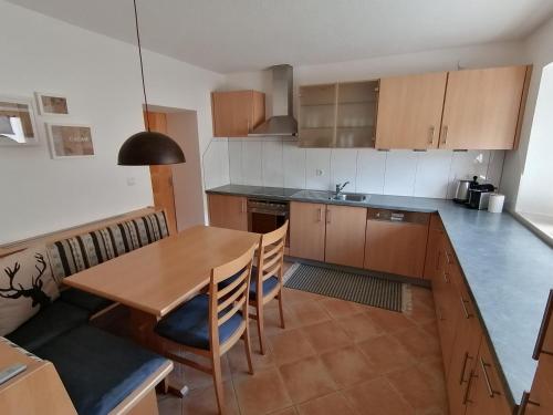 kuchnia z drewnianym stołem, stołem i krzesłami w obiekcie Living Apart Haslwanter Ferienwohnung w mieście Haiming
