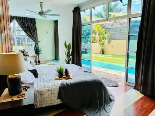 een slaapkamer met een bed en een groot raam bij Batu Pahat Santalia Pool Villa 4BR 1k4Q 12~16px in Batu Pahat