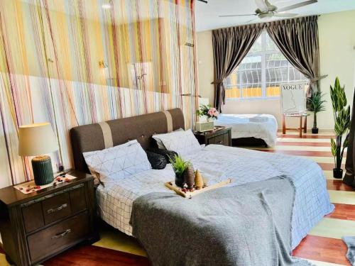 een slaapkamer met een bed met een blauw dekbed bij Batu Pahat Santalia Pool Villa 4BR 1k4Q 12~16px in Batu Pahat