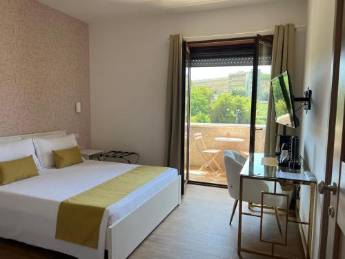sypialnia z łóżkiem i biurkiem oraz balkon w obiekcie yo yo house luxury room w mieście Napoli