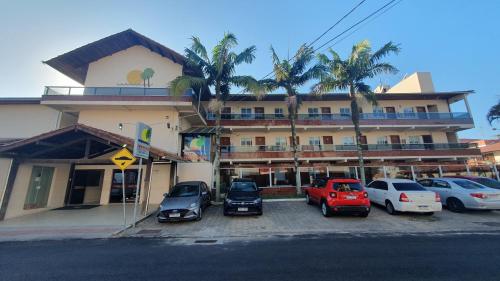 un edificio con coches estacionados en un estacionamiento en Tropicanas Hotel e Eventos, en Florianópolis