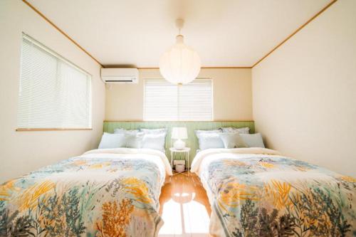 沖縄市にあるSHIOYA STAYのベッドルーム1室(ベッド2台、窓付)