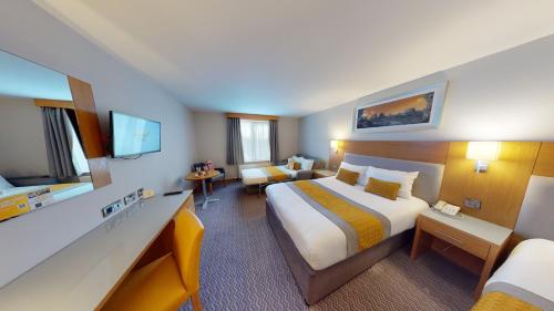 ポート・レーイシュにあるMaldron Hotel Portlaoiseの大きなベッドとソファが備わるホテルルームです。