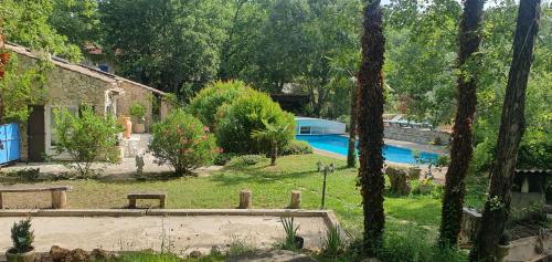 a yard with a pool and trees and a house at Villa Eden Vert in Fayence