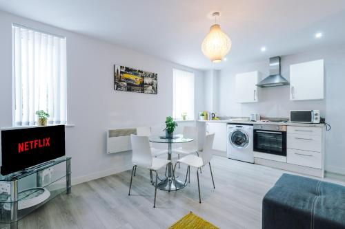 a kitchen and living room with a table and chairs at 1BR & 2BR Apt -for CONTRACTORS- free PARKING close to EVERTON & ANFIELD stadium, Liverpool City Centre managed by Chique Properties Ltd in Liverpool