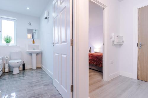 a white bathroom with a toilet and a sink at 1BR & 2BR Apt -for CONTRACTORS- free PARKING close to EVERTON & ANFIELD stadium, Liverpool City Centre managed by Chique Properties Ltd in Liverpool