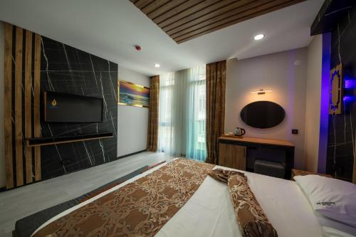 a bedroom with a large bed and a television at Air Barbaros Hotel Trabzon in Trabzon