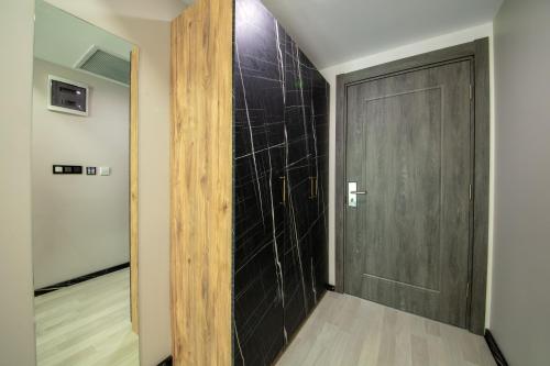 a hallway with a black door and a wooden floor at Air Barbaros Hotel Trabzon in Trabzon